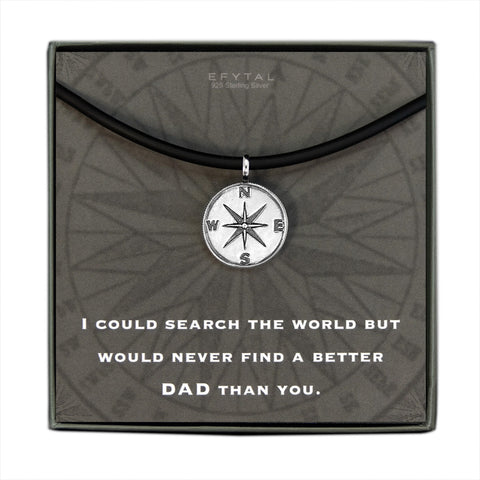 A grey jewelry box containing a grey message card with tonal compass motif. A black silicone cord with a Sterling Silver compass pendant rests on the card. The white text on the card reads “EFYTAL 925 Sterling Silver” at the top and “I COULD SEARCH THE WORLD BUT WOULD NEVER FIND A BETTER DAD THAN YOU.”  