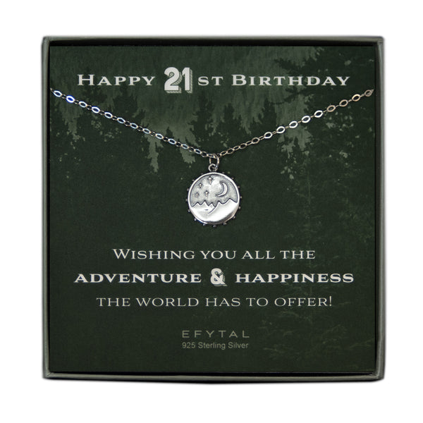 A grey jewelry box containing a green message card with a tonal forest motif. A 925 Sterling Silver necklace with a 925 sterling silver round pendant with mountain, moon and stars motif rests on the card. The white text on the card reads “HAPPY 21ST BIRTHDAY” at the top and “WISHING YOU ALL THE ADVENTURE & HAPPINESS THE WORLD HAS TO OFFER! EFYTAL 925 Sterling Silver” at the bottom.  