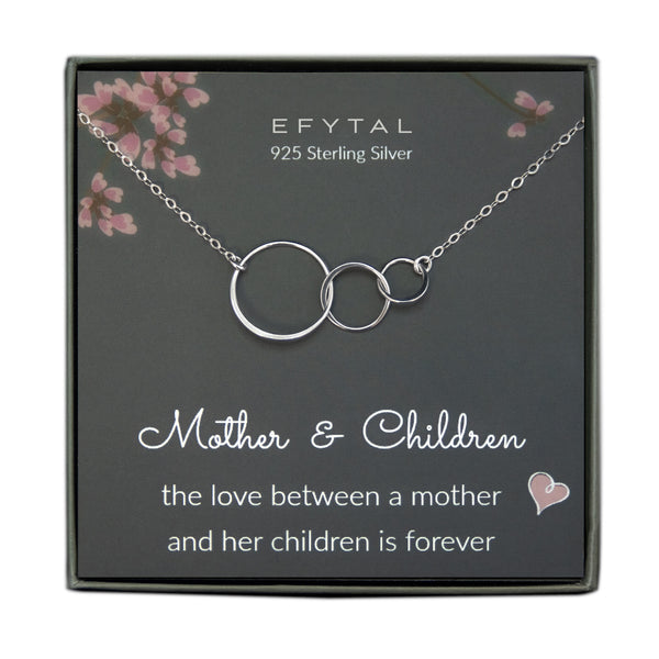 grey jewelry box containing silver necklace with three thin interlocking circles, placed on a grey card with pink flowers and branches at the top. the text on the card reads "EFYTAL 925 sterling silver" at the top and "Mother & Children - the love between mother <3 & her children is forever" at the bottom.