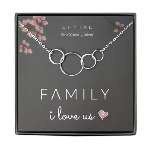 A grey jewelry box containing a grey message card with pink floral motif in the upper corners. A 925 Sterling Silver necklace with four interlocking rings of various size rests on the card. The white text on the card reads “EFYTAL 925 Sterling Silver” at the top and “FAMILY I love us <3” at the bottom.