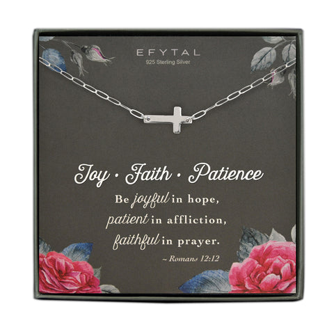 A grey jewelry box containing a grey message card with a pink and blue rose and rosebud motif in the corners. A 925 Sterling Silver necklace with a modern chain link and a sideways Sterling Silver cross pendant rests on the card. The white text on the card reads “EFYTAL” at the top and “Joy - Faith - Patience Be joyful in hope, patient in affliction, faithful in prayer - Romans 12:12” at the bottom.