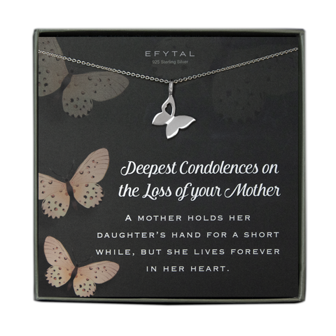 A grey jewelry box contains a grey message card with peach butterfly motif. A silver necklace with a butterfly pendant featuring a heart shaped cutout in one wing rests across the card. In white text, the card reads "EFYTAL 925 Sterling Silver" at the top and "Deepest Condolences on the Loss of your Mother A MOTHER HOLDS HER DAUGHTER'S HAND FOR A SHORT WHILE, BUT SHE LIVES FOREVER IN HER HEART."