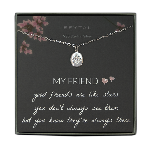 A grey jewelry box contains a grey message card with pink flower and branch motif at the top. A silver necklace with a puffy oval pendant rests on the card. The pendant has a star design in the center, studded with CZ stones. The white text at the top of the card reads "EFYTAL 925 Sterling Silver" and, at the bottom, "MY FRIEND <3 <3 good friends are like stars you don't always see them but you know they're always there"