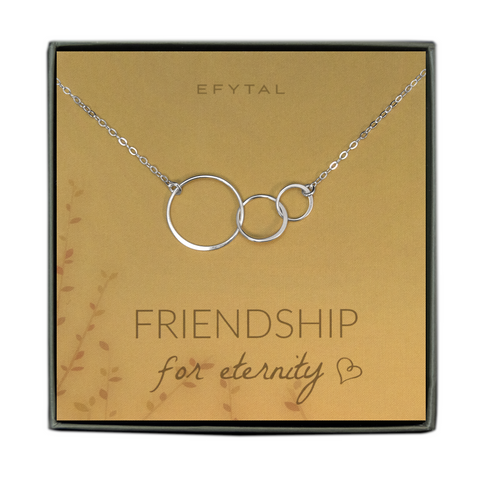  A grey jewelry box contains a yellow message card with a brown and orange leaf motif in the bottom left corner. A sterling silver necklace with three interlocking circles rests on the card. The brown text above the necklace reads "EFYTAL" and under the necklace reads "FRIENDSHIP for eternity <3" 