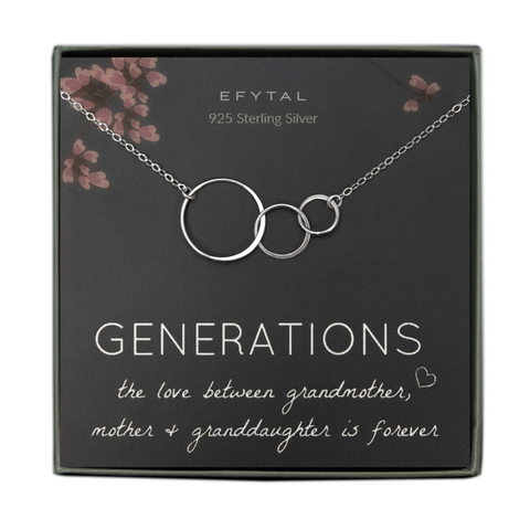 A grey jewelry box containing a grey message card with pink floral motif at the top. A sterling silver necklace with three thin interlocking circles of graduated sizes rests on the card. The white text on the card reads "EFYTAL 925 Sterling Silver" at the top and “GENERATIONS the love between grandmother <3, mother + granddaughter is forever”