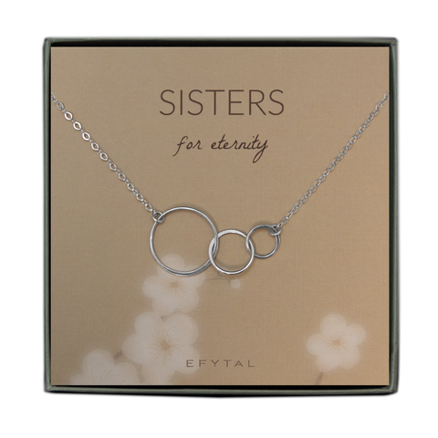 A grey jewelry box containing a beige message card with white floral motif at the bottom. A sterling silver necklace with three thin interlocking circles of graduated sizes rests on the card. The brown text on the card reads "EFYTAL 925 Sterling Silver" at the bottom and “SISTERS for eternity” at the top.
