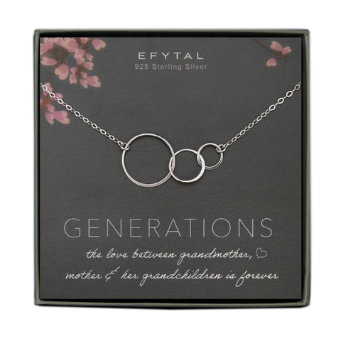A grey jewelry box containing a grey message card with pink floral motif at the top. A sterling silver necklace with three thin interlocking circles of graduated sizes rests on the card. The white text on the card reads "EFYTAL 925 Sterling Silver" at the top and “GENERATIONS the love between grandmother <3, mother & her grandchildren is forever”
