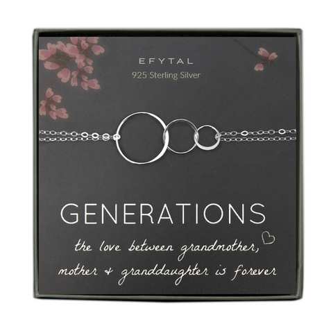 A grey jewelry box containing a grey message card with pink floral motif at the top. A sterling silver bracelet with three thin interlocking circles of graduated sizes rests on the card. The white text on the card reads "EFYTAL 925 Sterling Silver" at the top and “GENERATIONS the love between grandmother <3, mother + granddaughter is forever”