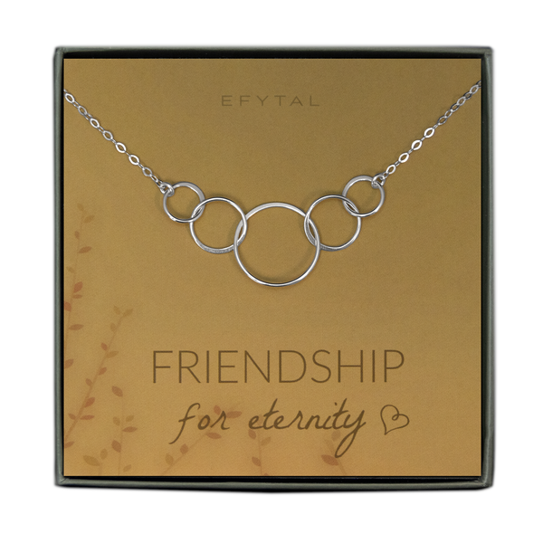 A green jewelry box holds a yellow jewelry card with brown leaf motif in the bottom left corner. A sterling silver necklace with five interlocked silver rings rests on the card. The text above the jewelry reads "EFYTAL" in brown font, and below the necklace the card says "FRIENDSHIP for eternity <3"