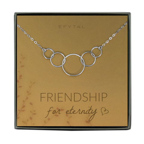 A green jewelry box holds a yellow jewelry card with brown leaf motif in the bottom left corner. A sterling silver necklace with five interlocked silver rings rests on the card. The text above the jewelry reads "EFYTAL" in brown font, and below the necklace the card says "FRIENDSHIP for eternity <3"