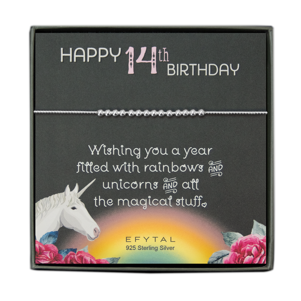 grey jewelry box containing silver bracelet with fourteen round silver beads, placed on a grey card. The bottom left corner of the card has a unicorn and roses, there is a rainbow in the bottom center, and a rose on the bottom right corner. The card reads "Happy 14th birthday" in pink and white font at the top, and "Wishing you a year filled with rainbows and unicorns and all the magical stuff <3" underneath in white. "EFYTAL 925 sterling silver" is in small dark text at the bottom of the card. 