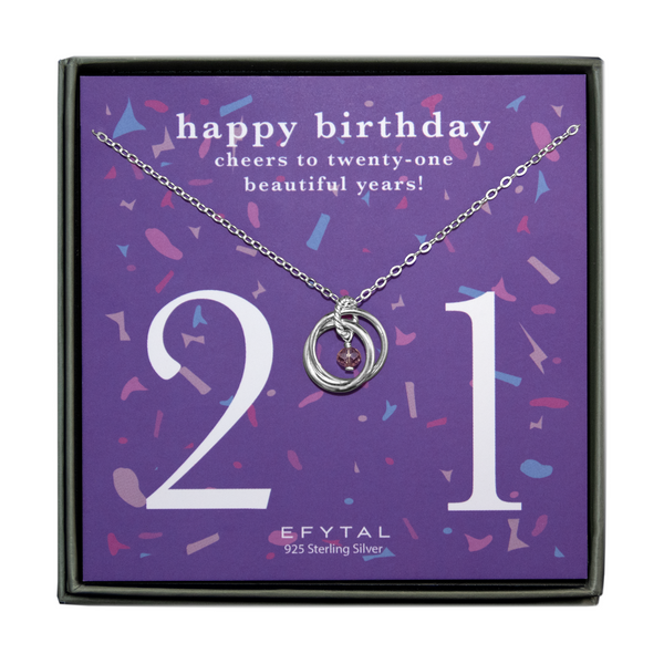 grey jewelry box containing silver necklace with two intertwined rings encircling a dangling purple gem, placed on purple card with confetti print and large number 21 in white font. the card reads "happy birthday. cheers to 21 beautiful years!" in white font at the top, and "EFTYAL 925 Sterling Silver" in small print at the bottom.
