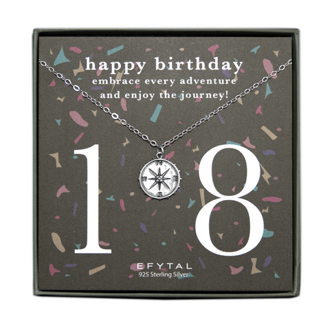 grey jewelry box containing silver necklace with a dimensional compass pendant, placed on a grey card with colorful confetti print and large number 18 in white font. the card reads "happy birthday. embrace every adventure and enjoy the journey!" in white font at the top, and "EFTYAL 925 Sterling Silver" in small print at the bottom.